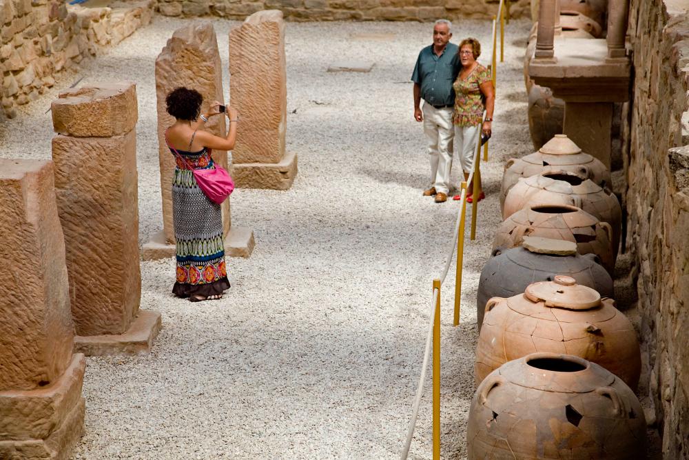 una chica sacando fotos a una pareja que posan delante de las tinajes de las Musas de Arellano